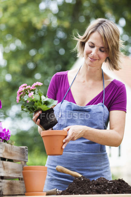 Portrait of woman potting flowers — Stock Photo