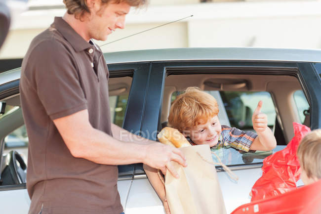 Padre e figli carico generi alimentari in auto — Foto stock