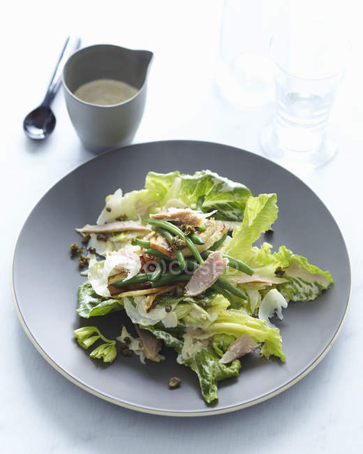Salada com atum servido com molho em caneca na mesa — Fotografia de Stock