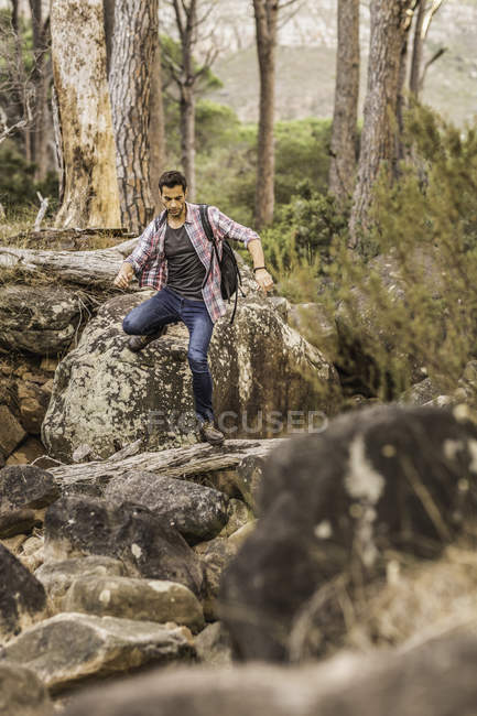 Male hiker hiking down forest rock formation, Deer Park, Cape Town, South Africa — Stock Photo