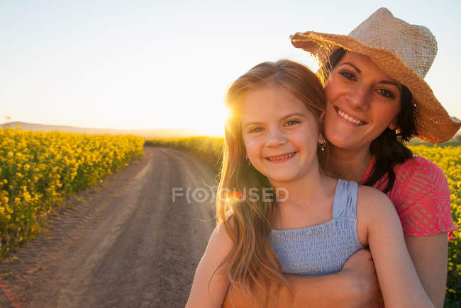 Madre e hija abrazándose en camino de tierra - foto de stock