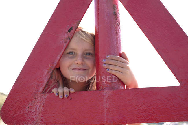 Retrato de menina olhando através do triângulo vermelho — Fotografia de Stock
