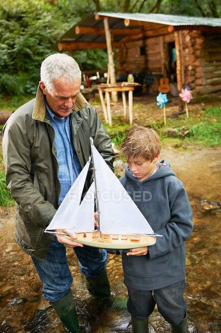 Grandfather and boy with sailing boat — Stock Photo