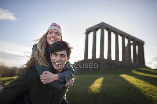 Молодая пара на Калтон-Хилл на фоне Национального памятника Шотландии в Эдинбурге — стоковое фото