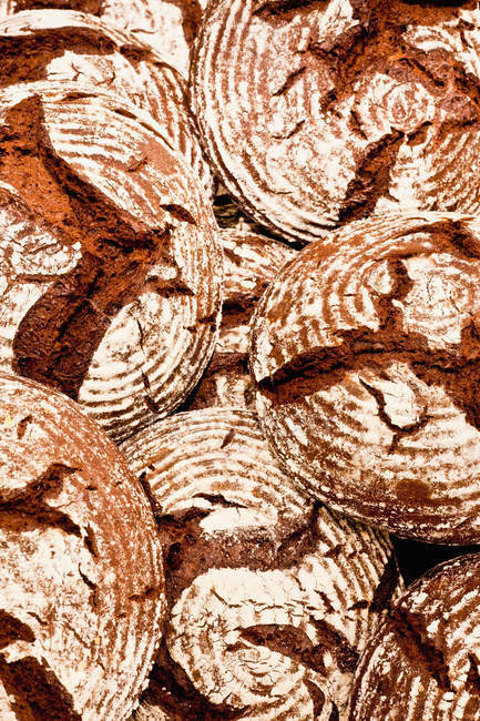 Pile of crusty bread loaves, top view — Stock Photo