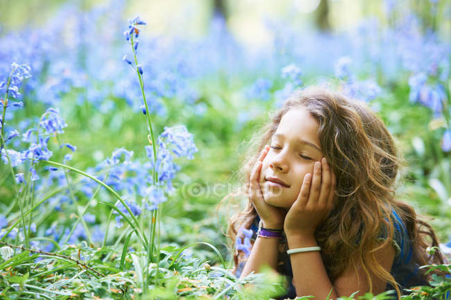 Mädchen liegt in einem Blumenfeld — Stockfoto