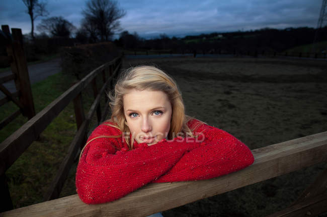 Дівчина-підліток спирається на дерев'яний паркан — стокове фото