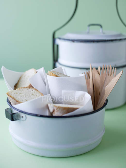 Tiffin tin with crusty bread slices — Stock Photo