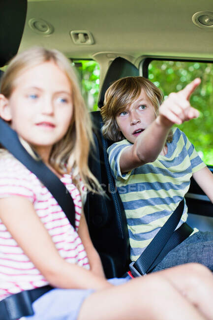 Crianças sentadas no banco de trás do carro — Fotografia de Stock
