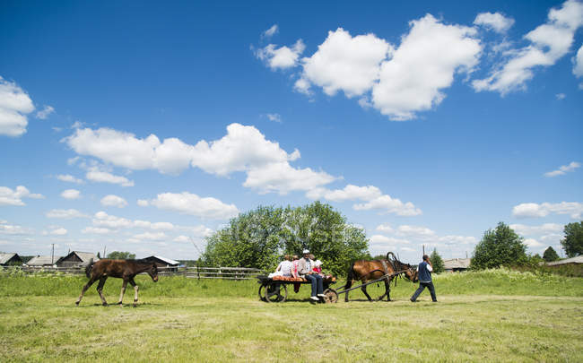 Сім'я верхи на коні і візок в полі, Rezh, Свердловська область, Росія — стокове фото