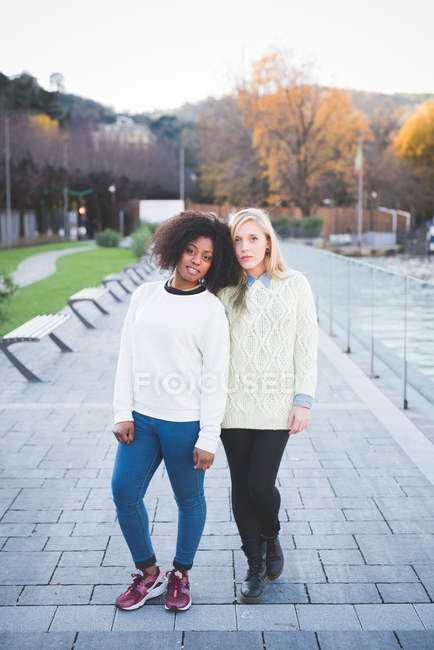 Retrato de dos amigas jóvenes en el parque junto al lago, Como, Italia - foto de stock