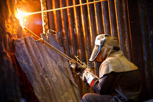 Soldador en el trabajo en forja de acero - foto de stock