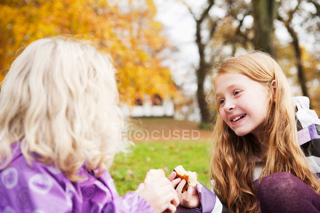 Girls eating together outdoors — Stock Photo