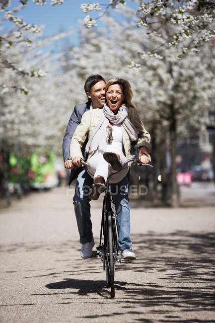 Hombre montando con novia en bicicleta - foto de stock