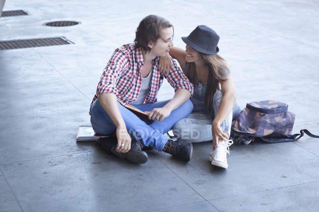 Giovane coppia seduta sul pavimento — Foto stock
