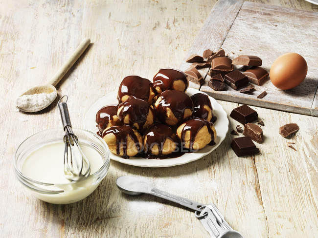 Profiteroles with hot chocolate sauce on table — Stock Photo