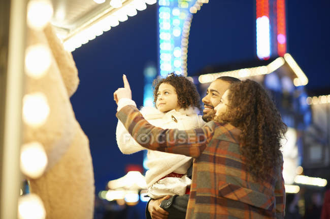 Young family enjoying funfair — Stock Photo