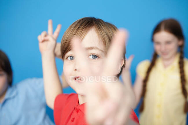 Portrait of boy making peace sign — Stock Photo