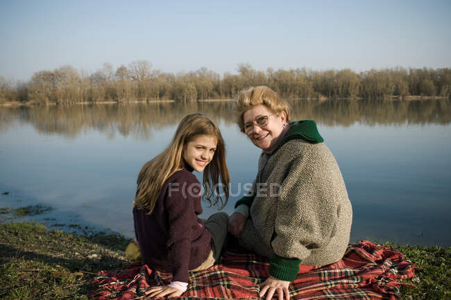 Grandmother and granddaughter on rug — Stock Photo