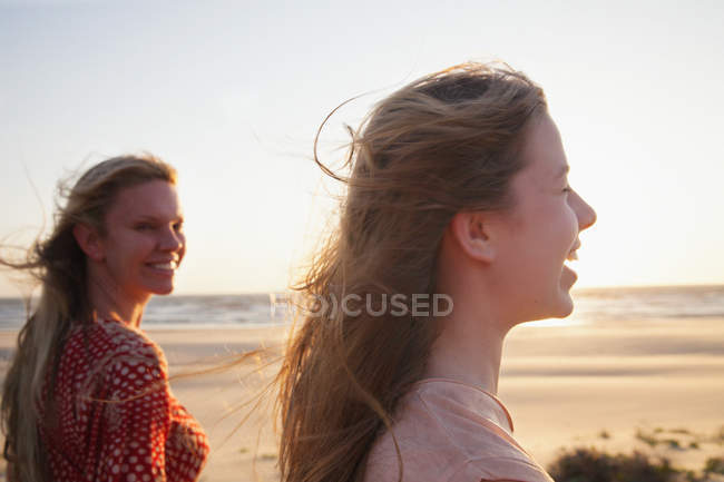 Madre e hija de pie en la playa ventosa - foto de stock