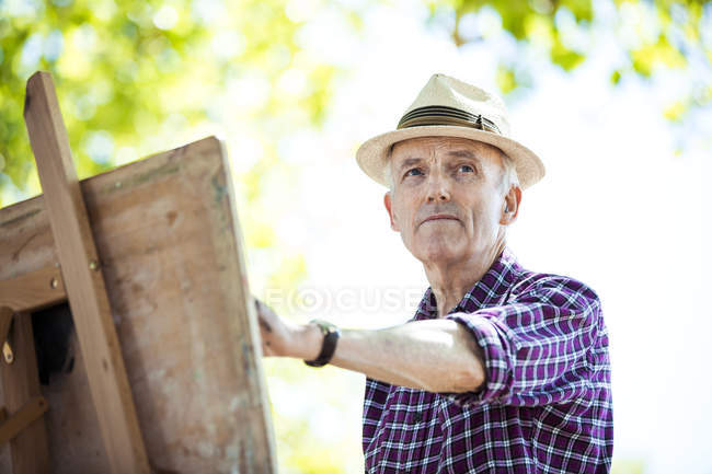 Senior man drawing in park, Hackney, London — Stock Photo