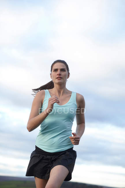 Женщина бежит на свежем воздухе, фокусируется на переднем плане — стоковое фото
