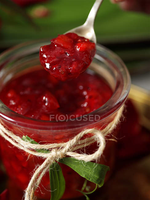 Jar of homemade redcurrant jam and spoon — Stock Photo
