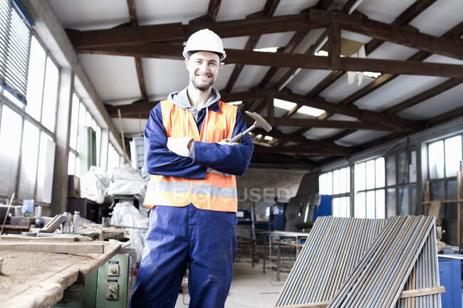 Портрет фабричного рабочего с молотком на бетонном арматурном заводе — стоковое фото