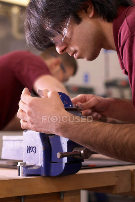 Worker using saw in factory — Stock Photo