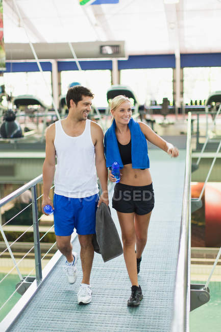 Pareja caminando juntos en el gimnasio - foto de stock