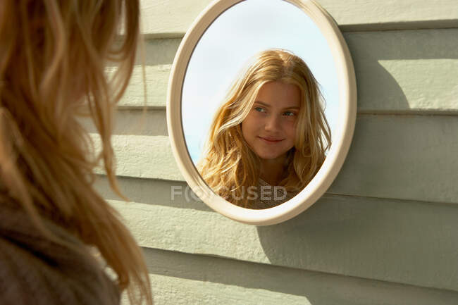 Jovem mulher olhando no espelho fora — Fotografia de Stock