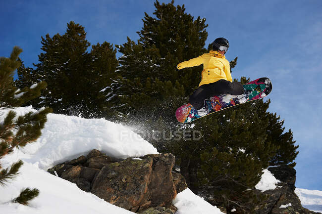 Jeune femme snowboarder saut — Photo de stock