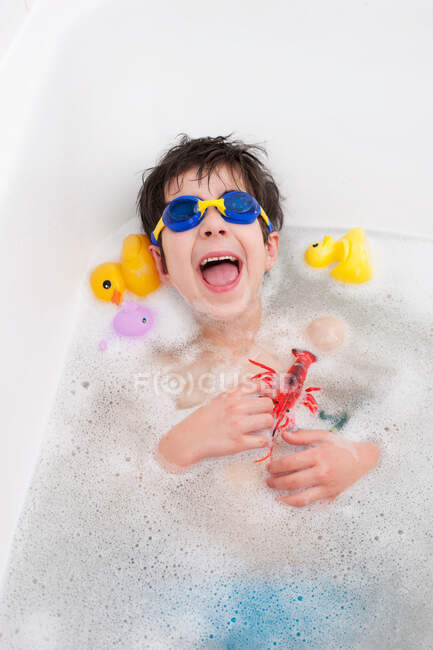 Niño en máscara de snorkel riendo en el baño - foto de stock
