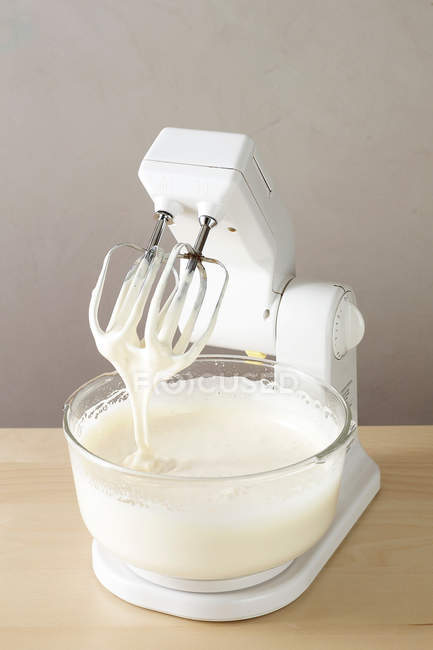 Mixer with cream in bowl — Stock Photo