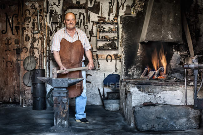 Retrato de herrero sénior en taller tradicional, Cagliari, Cerdeña, Italia - foto de stock