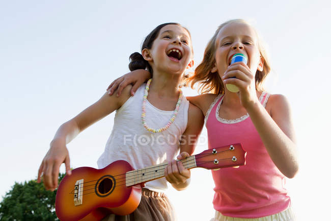 Chicas cantando juntas al aire libre - foto de stock