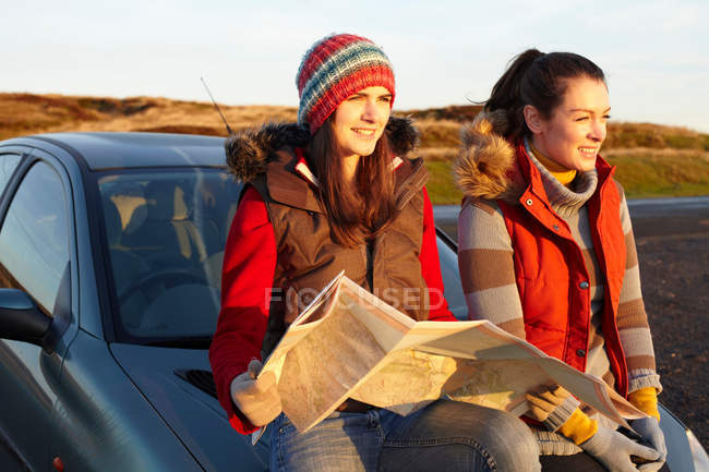 Mujeres leyendo mapa en coche - foto de stock