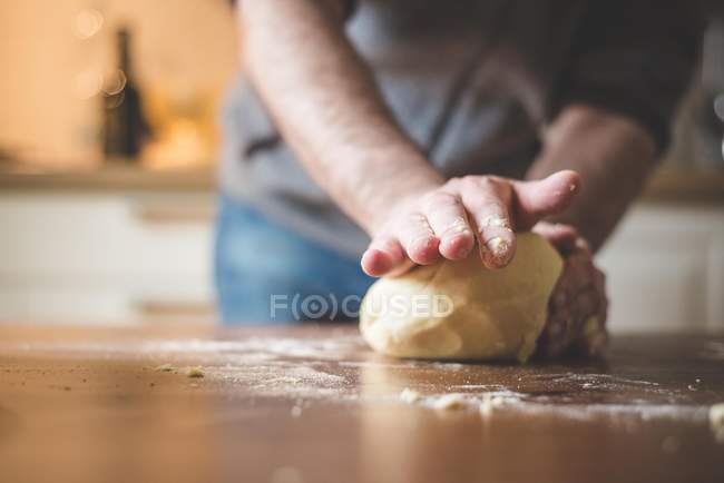 Imagem cortada do homem amassar massa na cozinha — Fotografia de Stock