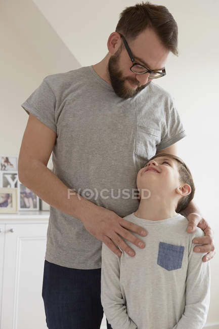 Niño con las manos de padre en los hombros - foto de stock