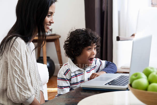 Mother and son using laptop in living room — Stock Photo