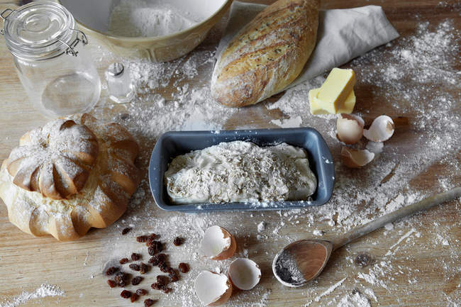 Pan panes y masa en el mostrador de cocina desordenado - foto de stock