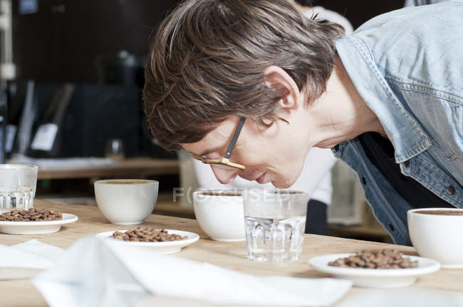 Coffee taster smelling cup of coffee — Stock Photo