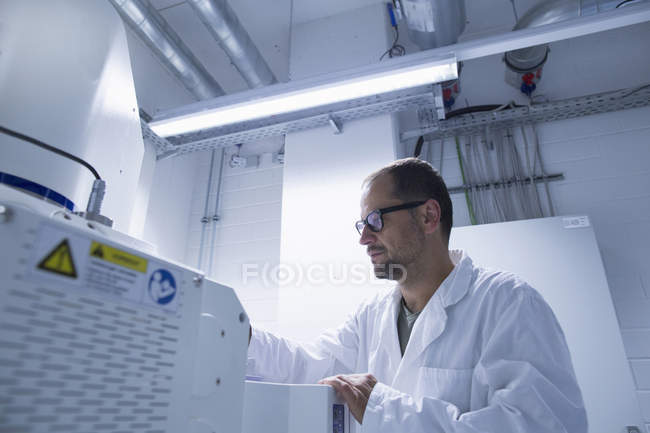 Assistente di laboratorio che lavora su attrezzature scientifiche — Foto stock