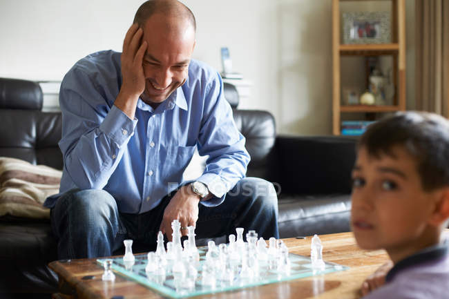 Отец и сын играют в шахматы вместе — стоковое фото