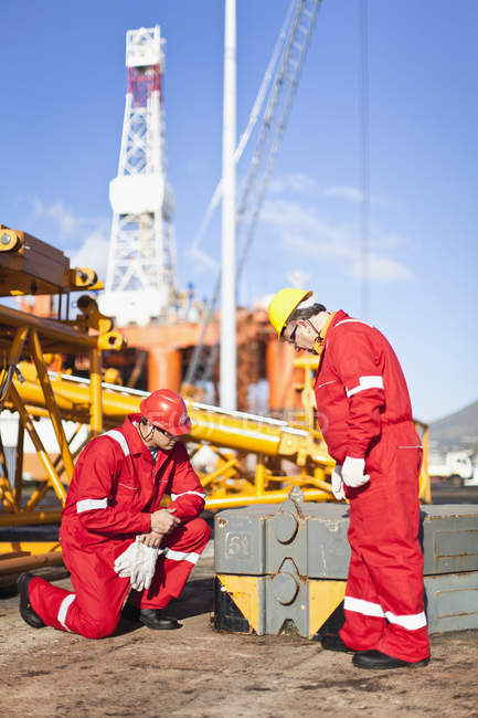Trabajadores en plataformas petrolíferas que examinan los equipos - foto de stock