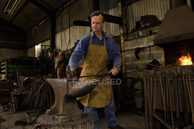 Male caucasian blacksmith at work in workshop — Stock Photo