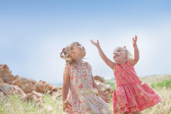 Meninas jogando na grama alta ao ar livre — Fotografia de Stock