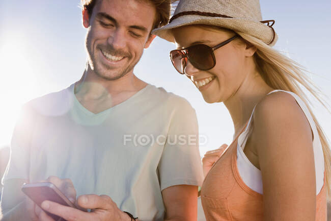 Молодая пара смотрит на смартфон — стоковое фото