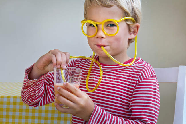 Мальчик пьет через соломинку — стоковое фото