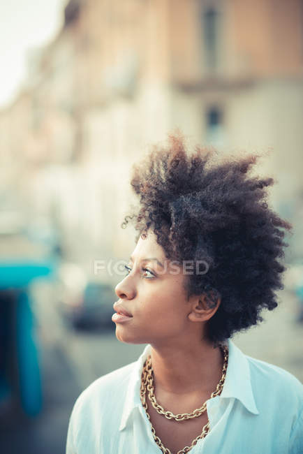 Retrato de bela jovem mulher olhando na cidade — Fotografia de Stock